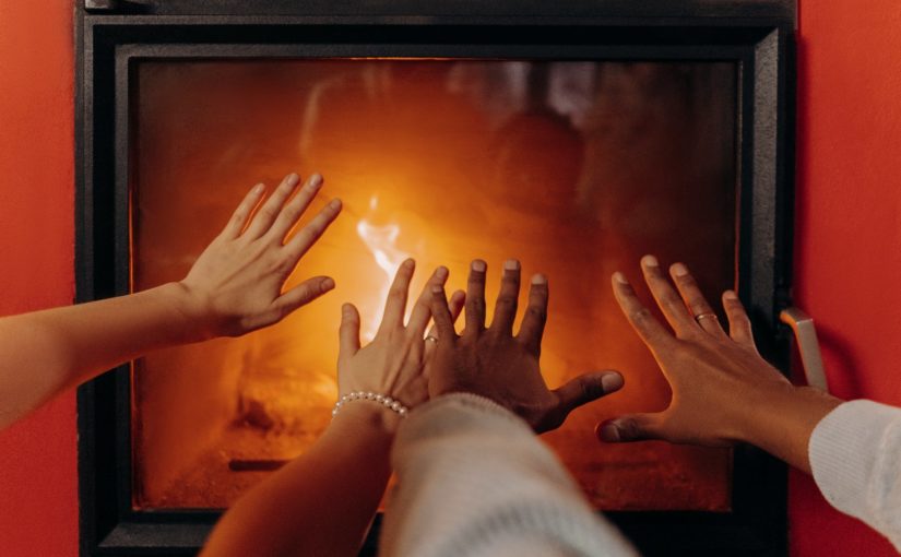 couples hands by fireplace